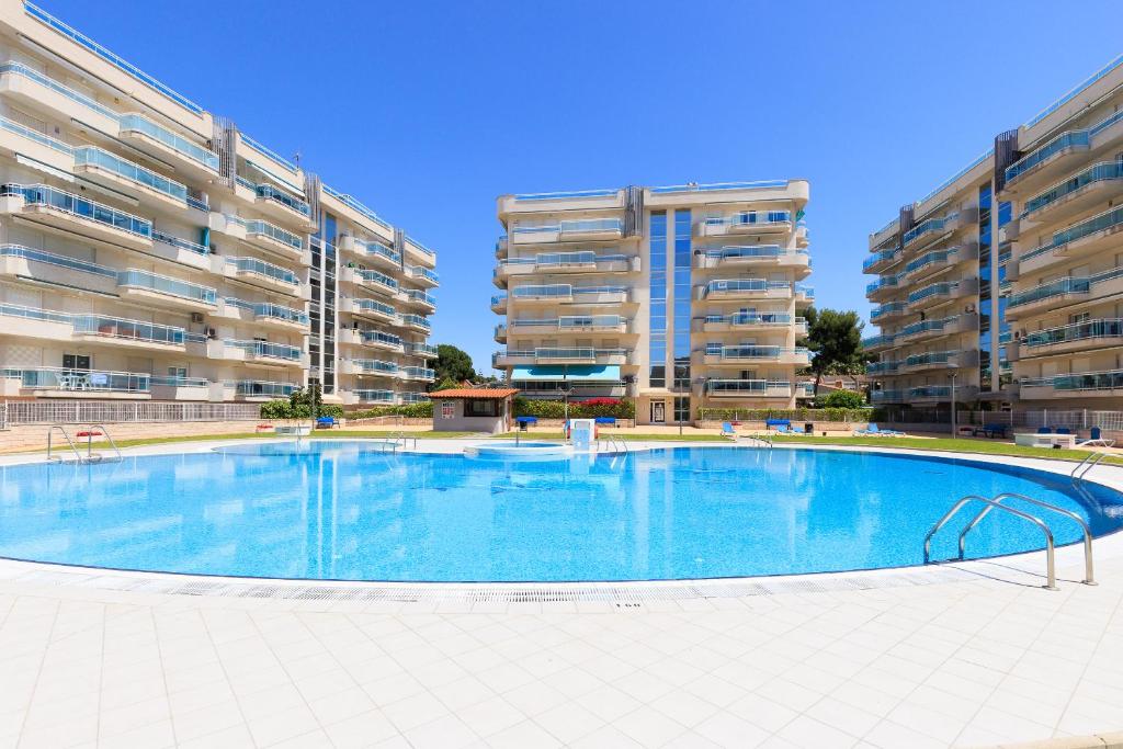 a large swimming pool in front of two apartment buildings at UHC Larimar Family Complex in Salou