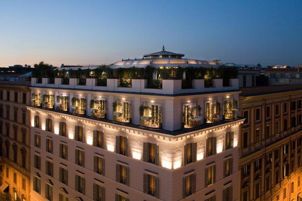 un bâtiment avec des lumières au-dessus de celui-ci la nuit dans l'établissement Hotel Isa, à Rome