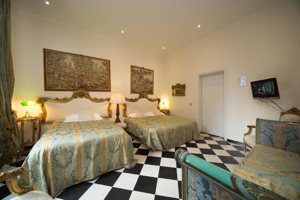 a hotel room with two beds and two lamps at San Giorgio Rooms in Genoa