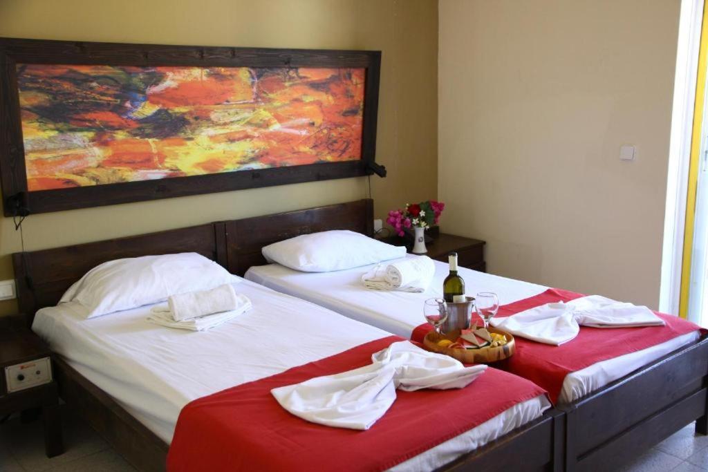 - 2 lits jumeaux dans une chambre avec draps rouges dans l'établissement Porto Plazza Hotel, à Chersónissos