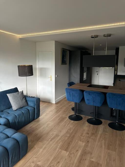 un salon avec un canapé bleu et une table dans l'établissement La suite Curial, à Paris