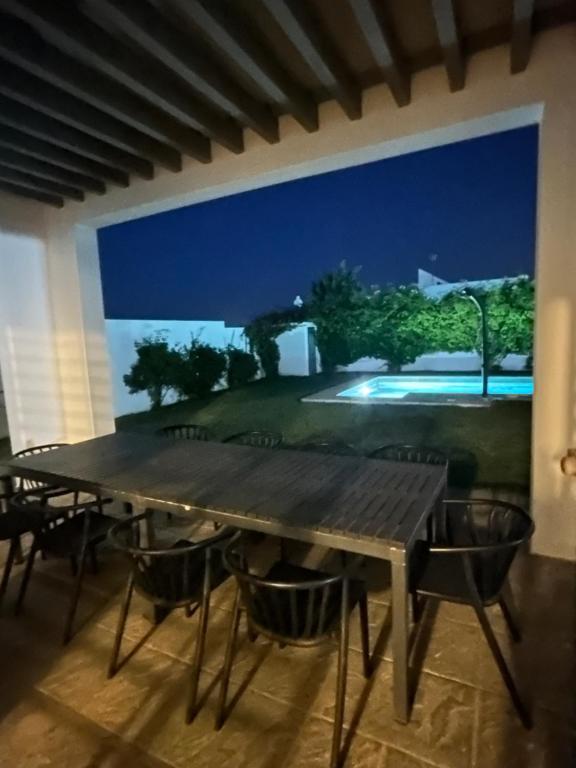 jadalnia z dużym drewnianym stołem i krzesłami w obiekcie Chalets conilizate 12 pax piscina 300mts playa w mieście Conil de la Frontera