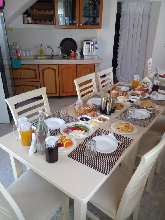 un tavolo bianco con piatti di cibo sopra di GUEST HOUSE “ Center Theth “ a Theth