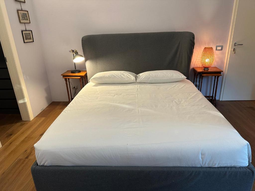a large bed in a bedroom with two night stands at Villa Dom in Piacenza