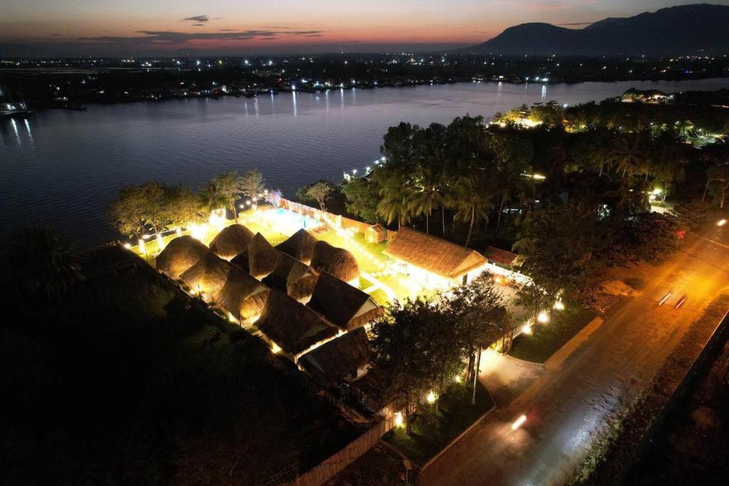 an aerial view of a lake at night with lights at SEA SAND RESORT in Kampot