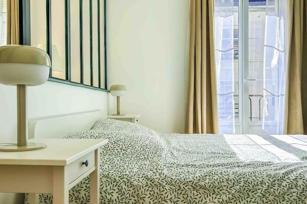 une chambre avec un lit et une table avec une lampe dans l'établissement Au coeur du centre ville, à Dieppe