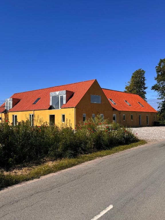 a house with red roofs on the side of a road at Amazing holiday apartment - Clara in Ebeltoft