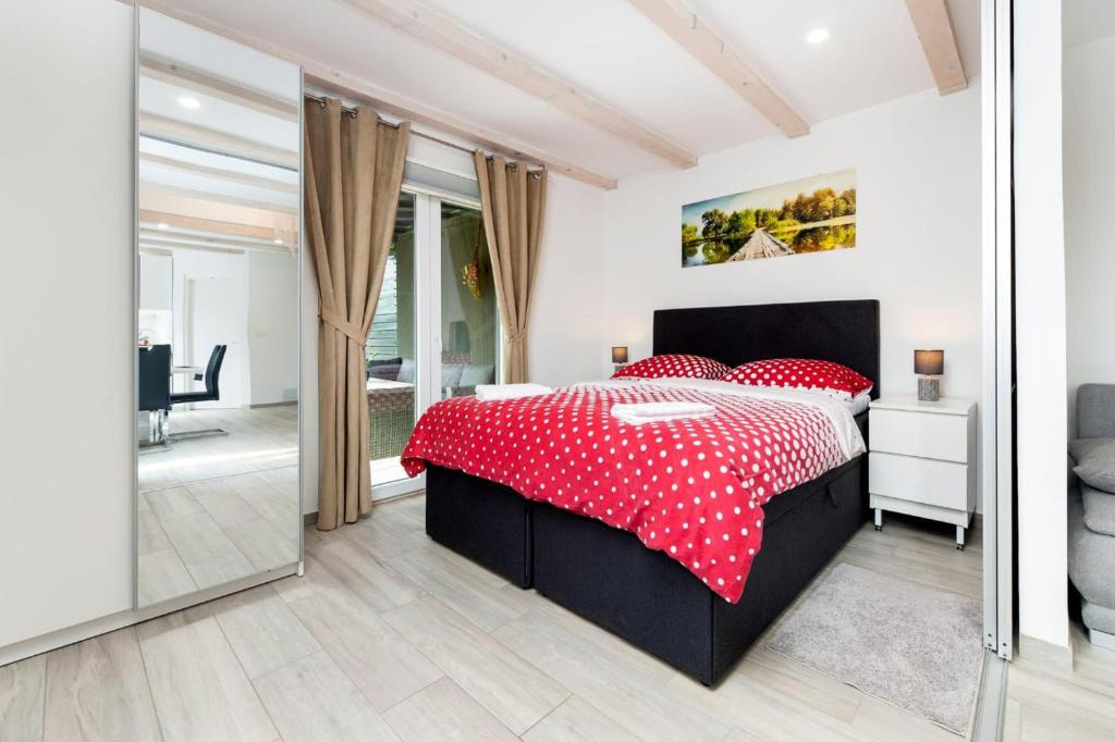 1 dormitorio con 1 cama con sábanas de lunares rojas en RENATA Mare HOLLIDAY HOUSE, en Rovinj