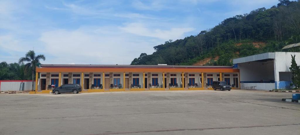 un edificio arancione con auto parcheggiate in un parcheggio di Teresra Hotel a Takung-hilir