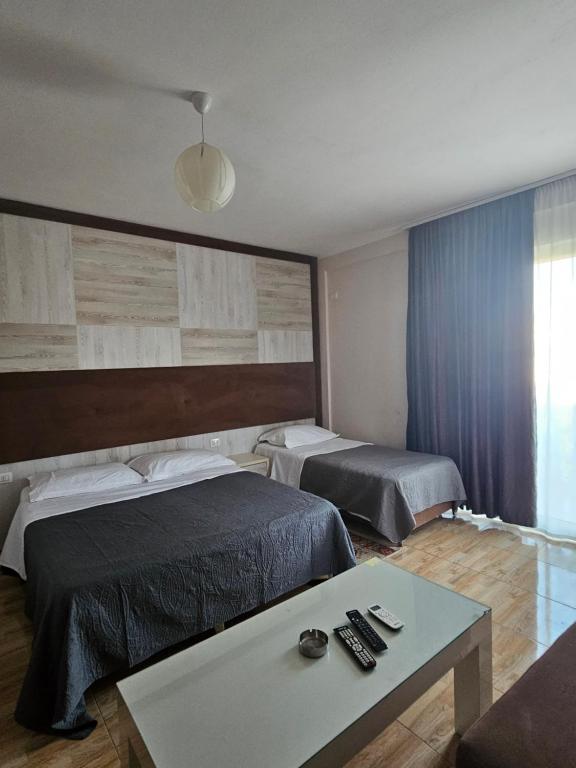 Habitación de hotel con 2 camas y mesa en Hotel 045, en Shkodër