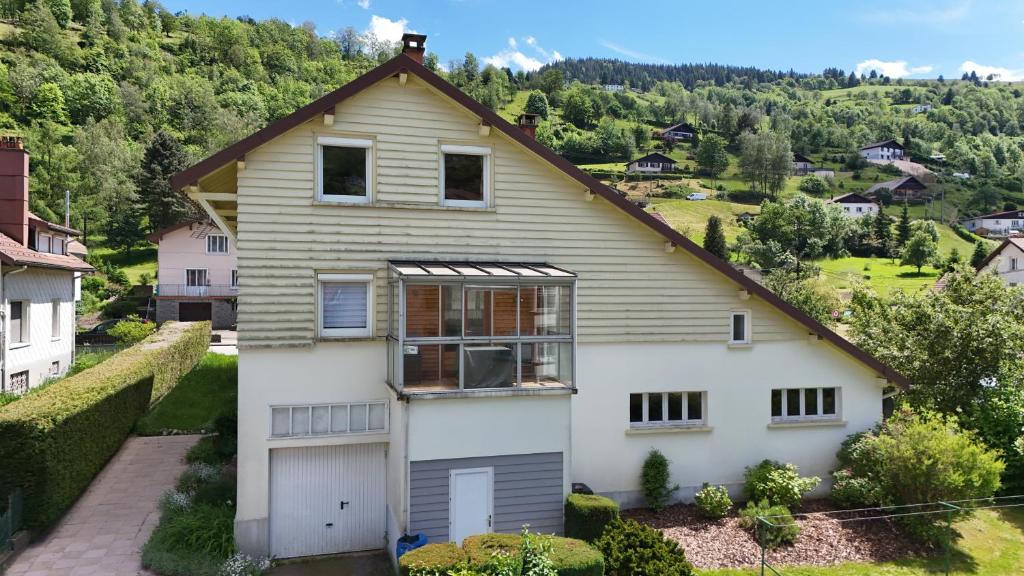 une maison blanche avec un toit marron dans l'établissement GITE La SCHLITTE, à La Bresse
