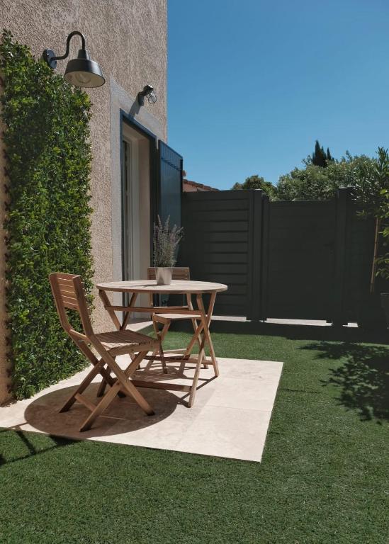 - une table de pique-nique et 2 chaises sur l'herbe dans l'établissement Studio rénové avec belle terrasse, à Aix-en-Provence