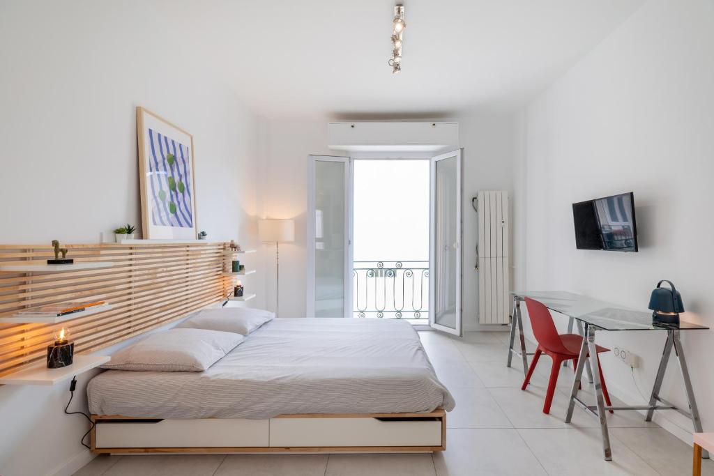 une chambre blanche avec un lit et un bureau dans l'établissement Beau Studio Le Grand Palais 100m des plages, à Juan-les-Pins