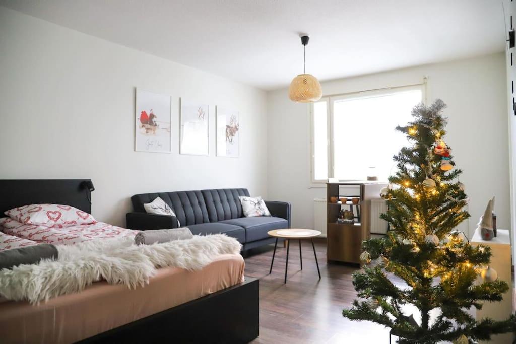 - un salon avec un arbre de Noël et un canapé dans l'établissement Rovaniemi City Centre Apartments, à Rovaniemi