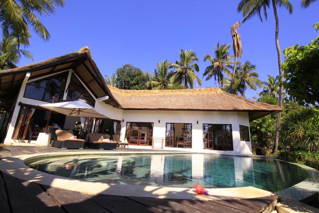 eine Villa mit einem Pool vor einem Haus in der Unterkunft Kembali Villa in Kubutambahan