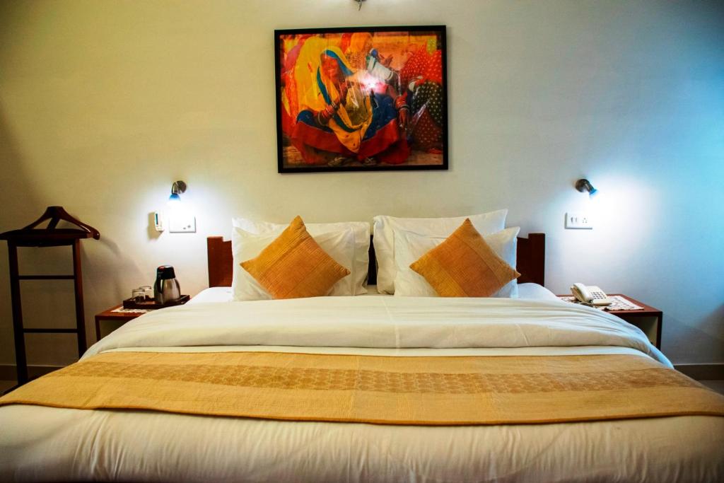 - une chambre avec un grand lit orné d'une peinture murale dans l'établissement Girisadan Boutique Hotel, à Jaipur