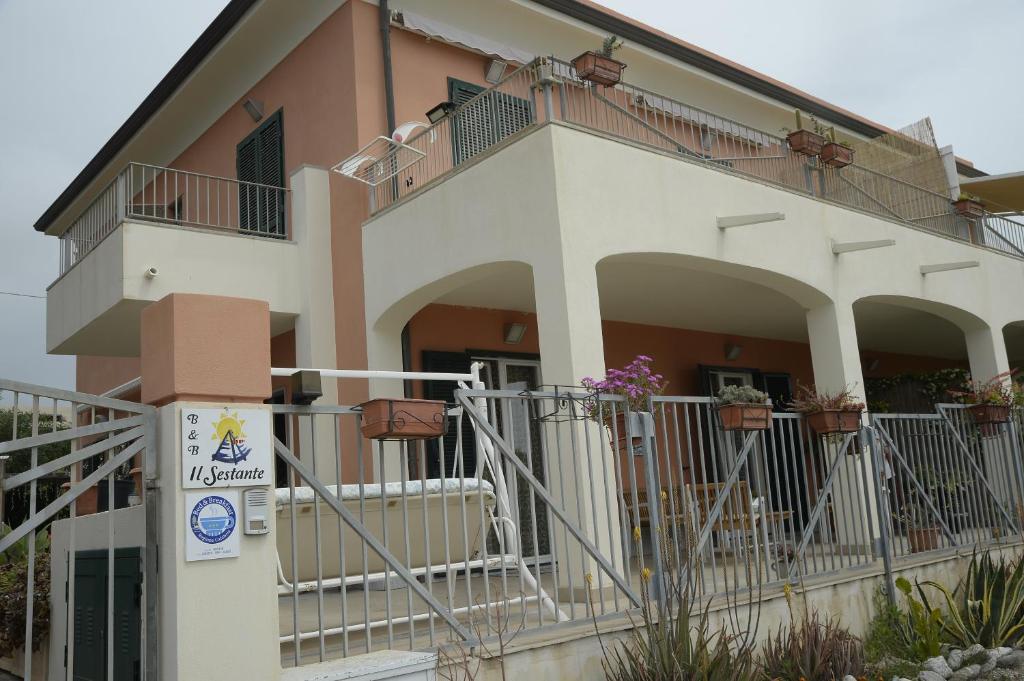 a building with a balcony and a sign in front of it at Il Sestante B&B in Condofuri