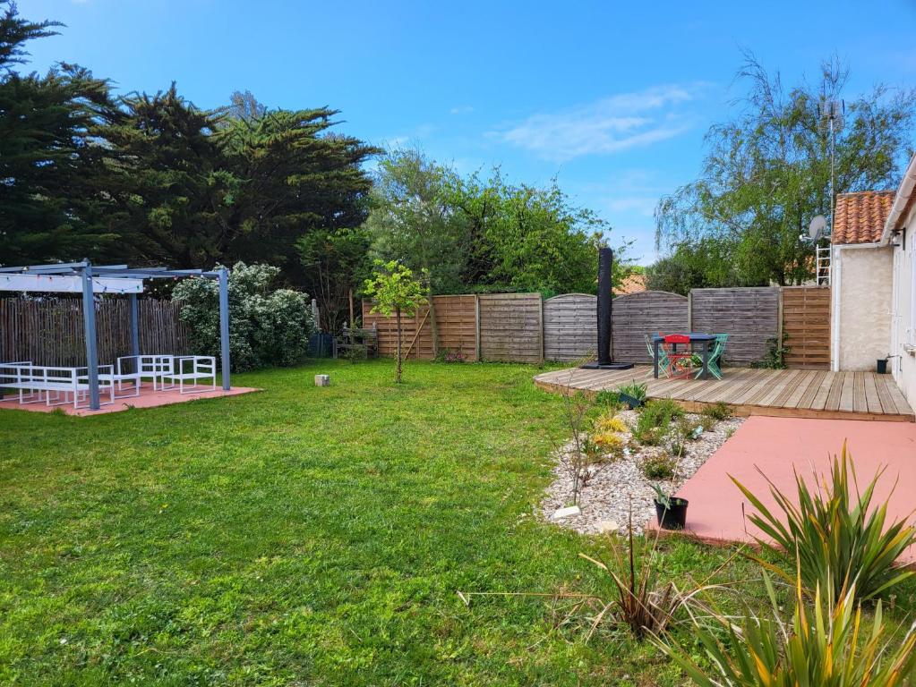 un jardin avec une terrasse et une aire de jeux dans l'établissement A 150m de la plage, Maison moderne et spacieuse pour 7 personnes, à Les Sables Vignier