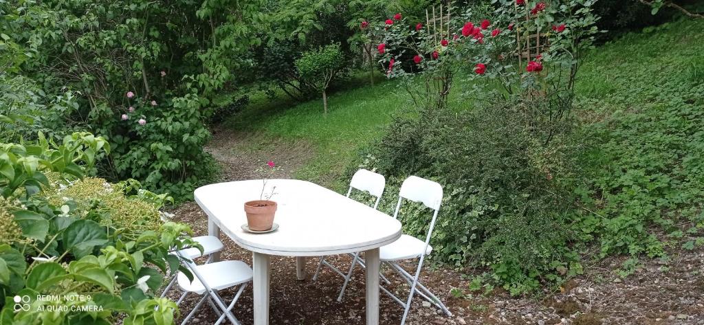 - une table et des chaises blanches dans le jardin dans l'établissement Appart' bucolique en plein centre ville, à Condom