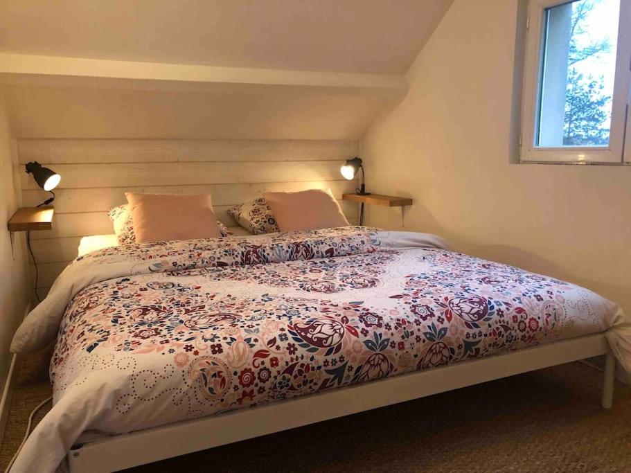 a bedroom with a bed with a comforter and a window at Magnifique Maison de Ville in Lormont