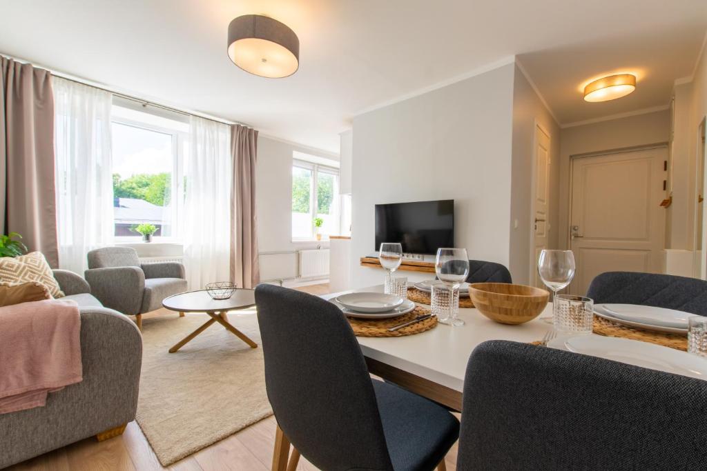 a living room with a table and chairs and a couch at Parkside Central Apartment by Kuus Sõlme in Kuressaare