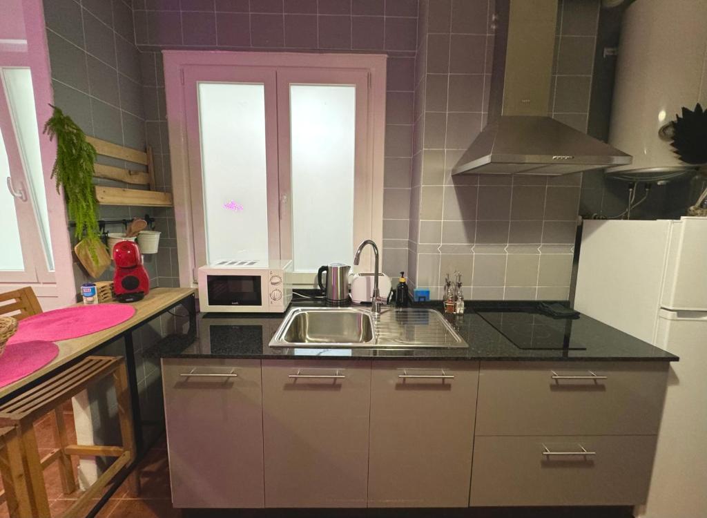 a kitchen with a sink and a microwave at Marukichan, apartamento en el centro de Vigo in Vigo