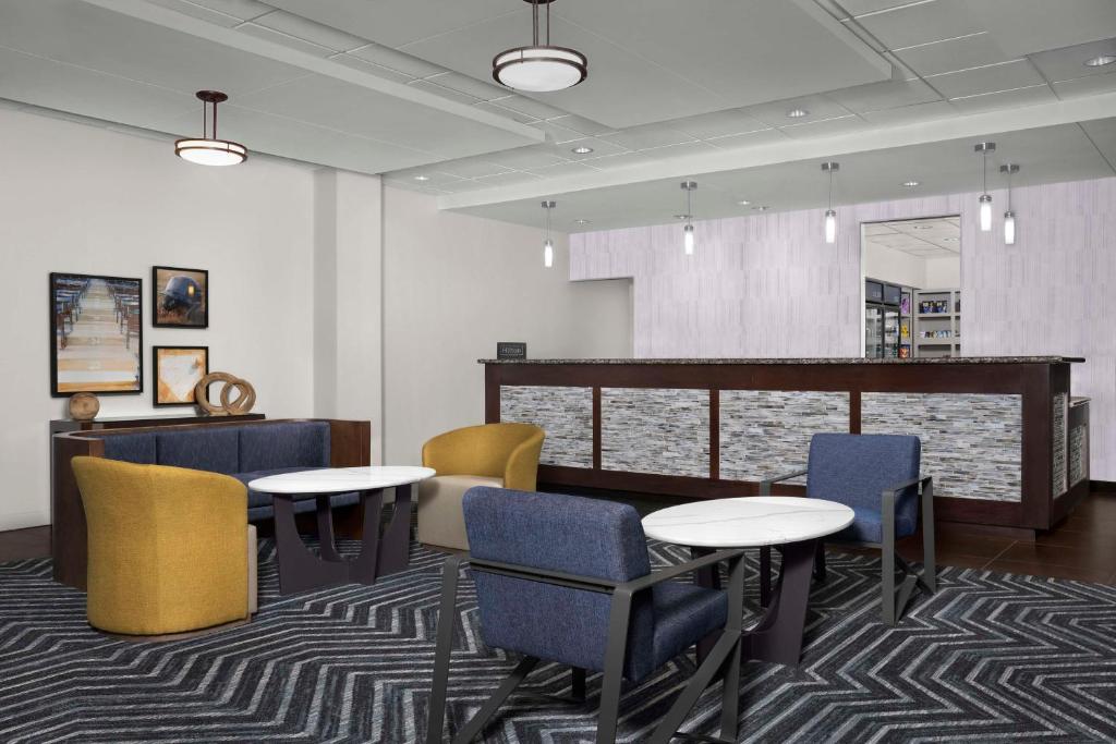 a waiting room with tables and chairs and a counter at Homewood Suites by Hilton Omaha - Downtown in Omaha
