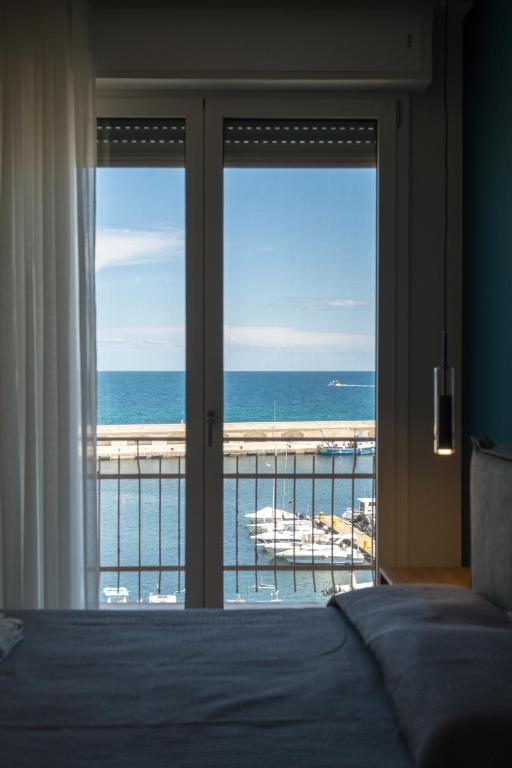 a bedroom with a bed and a view of the ocean at Pier Boutique Apartment in Mola di Bari