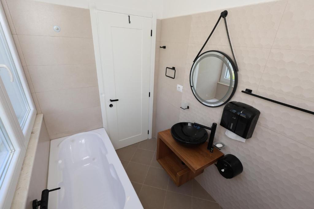 bagno con lavandino e specchio a parete di Baza Hostel - Swimming Pool a Berat