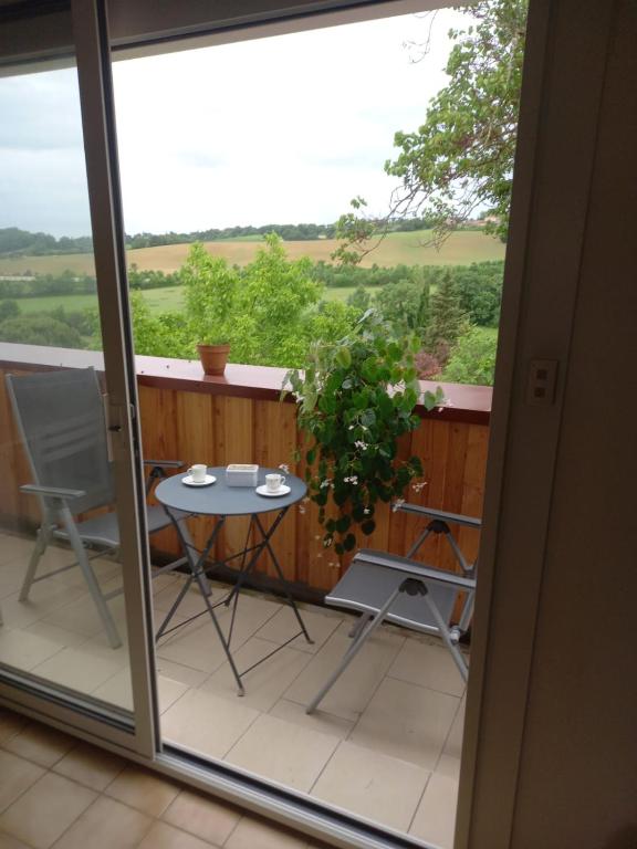 un balcon avec une table et des chaises et une vue dans l'établissement Location saisonnière par nuitée, à Duran