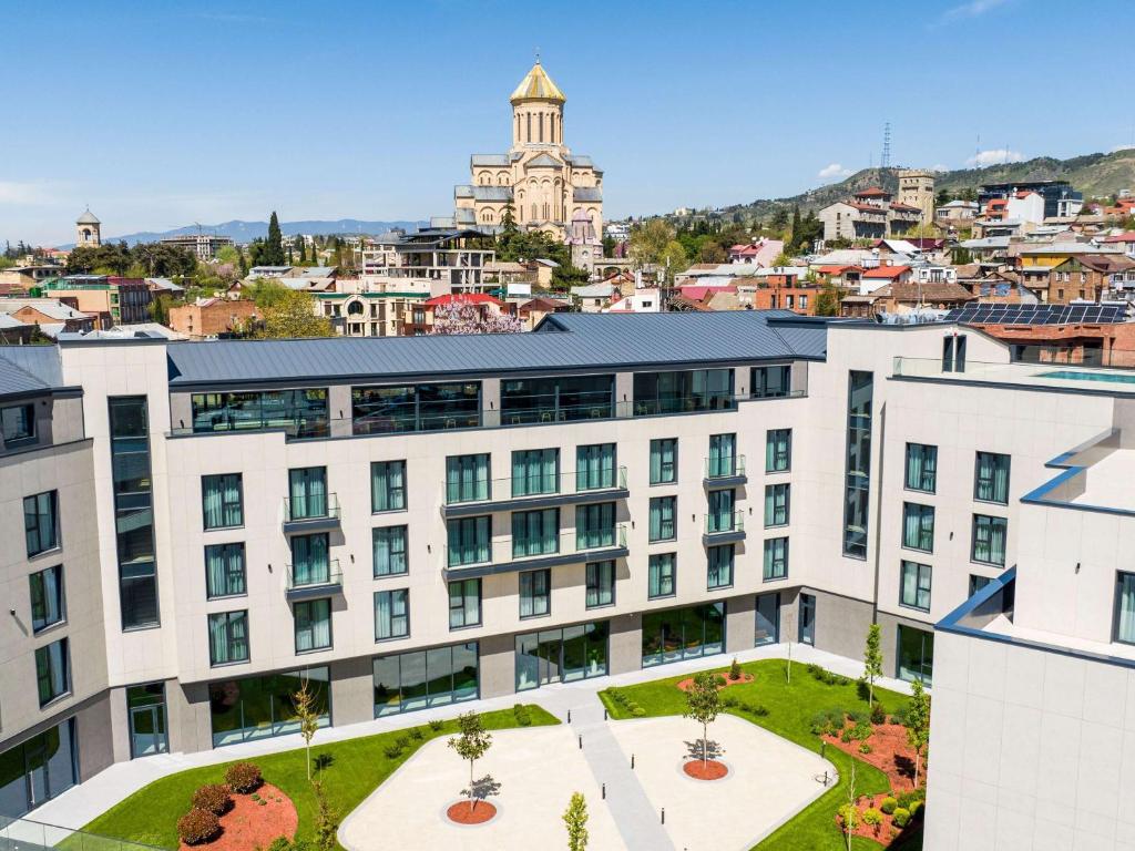 an apartment building with a view of a city at Novotel Tbilisi Center in Tbilisi City