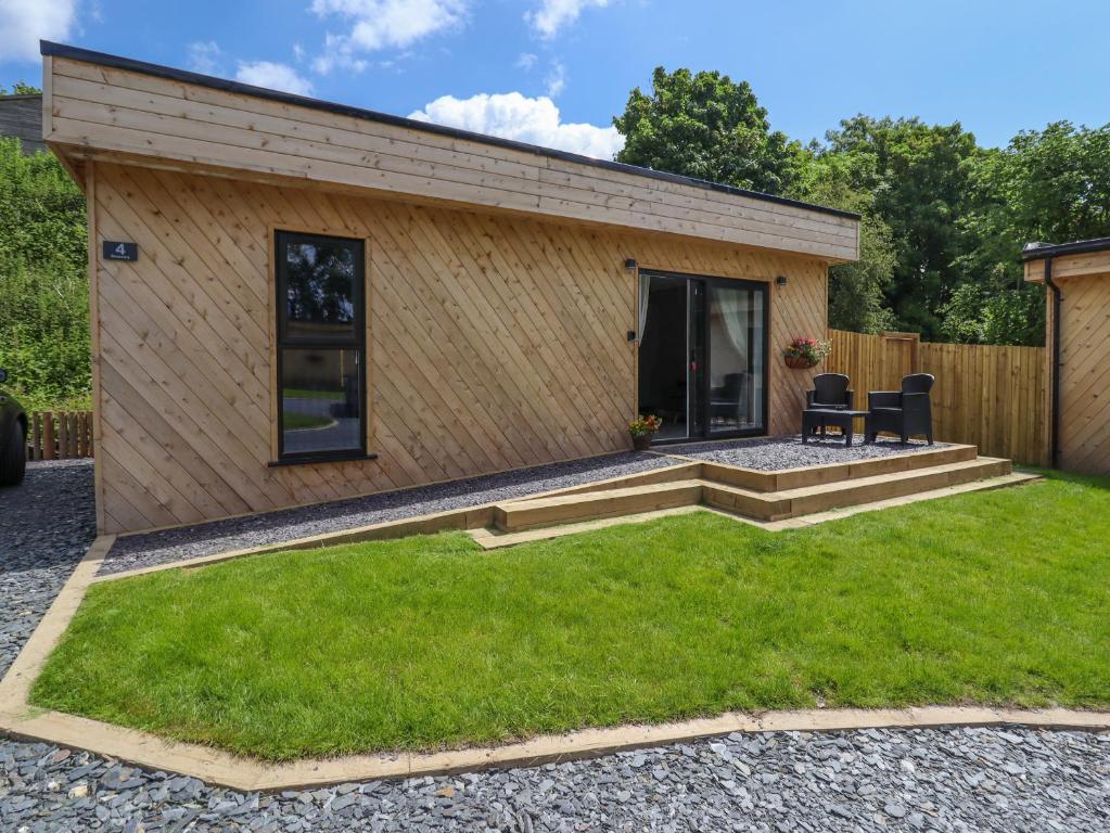 a tiny house with a patio and grass at Valley Lodge 4 - North Wales Eco Lodges in Ruthin