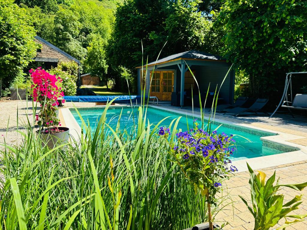 una piscina con gazebo e alcuni fiori di La mosane a Profondeville
