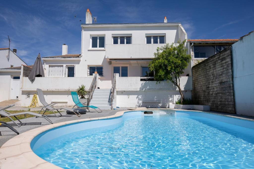 uma piscina em frente a uma casa em Belle Maison familiale avec piscine et jardin em Puilboreau