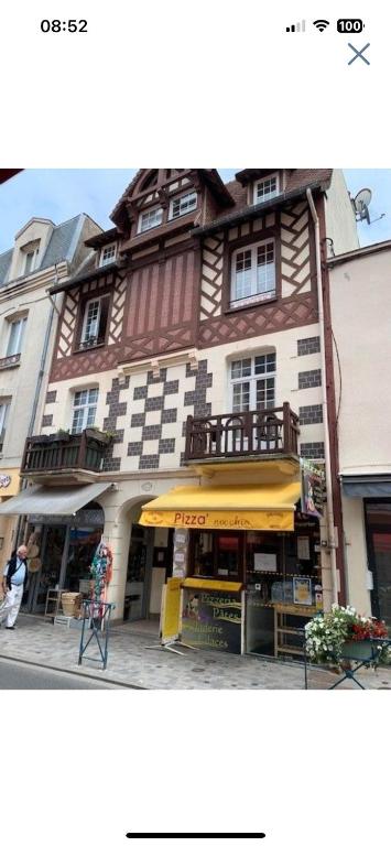 un grand bâtiment avec un magasin devant dans l'établissement VILLERS DEAUVILLE NOUVEAU STUDIO 2 Pers 30m de la plage, à Villers-sur-Mer