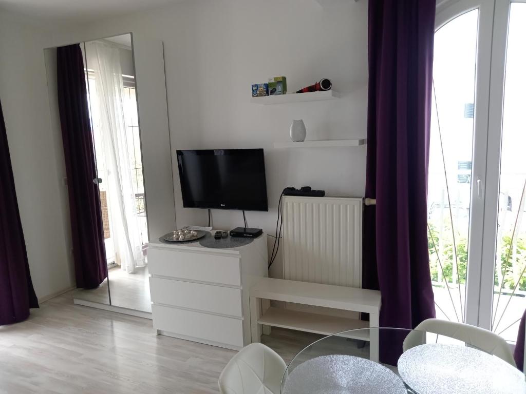 a living room with a tv and a dresser with a tvicterictericter at Ana Rooms in Krk
