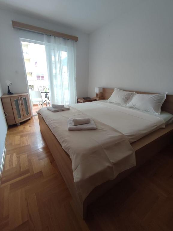 a bedroom with a large bed with two towels on it at Merkur Lux in Budva