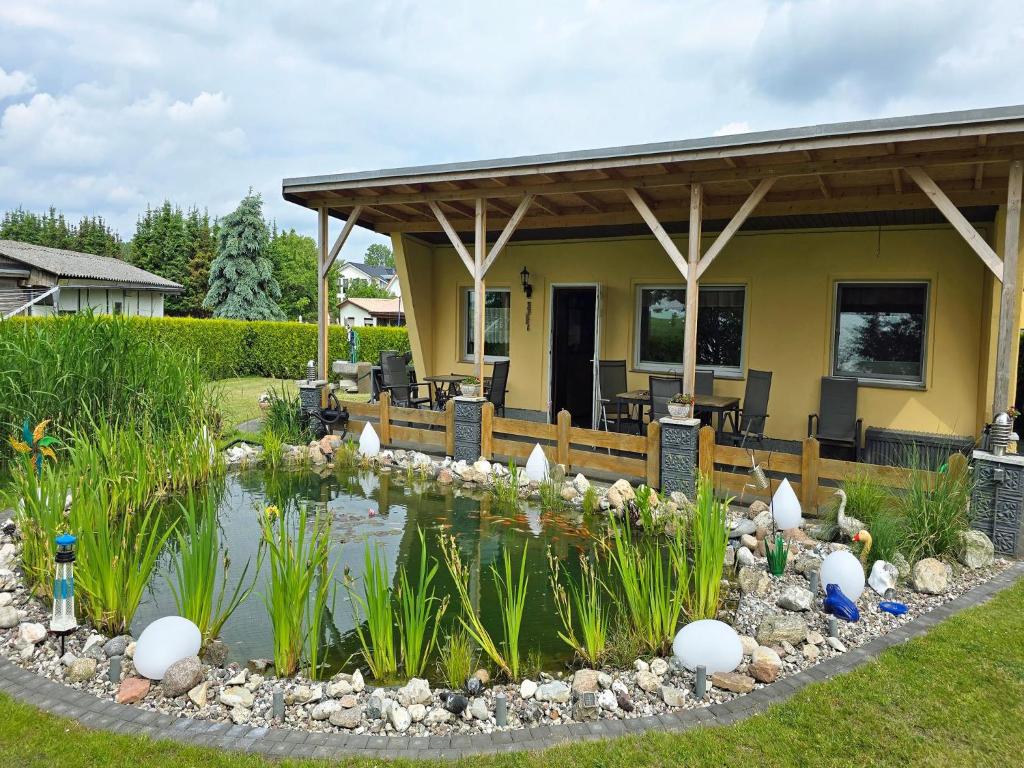a house with a pond in the yard at Ferienhaus am Wiesengrund in Sagard