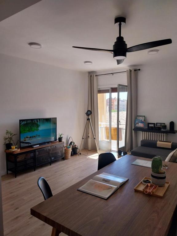 a living room with a table and a television at Apartamento grande en Huesca in Huesca