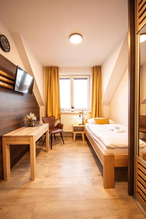 a hotel room with a bed and a table at Penzión Esprit in Sučany