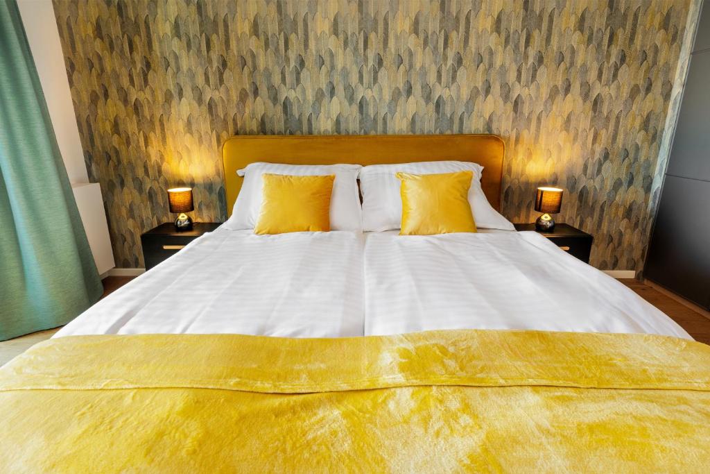 a bedroom with a large bed with yellow pillows at SKY PARK 1 - Luxurious #INSTAworthy Apartment in Downtown City Center with Included Parking, Best Address in Town in Bratislava