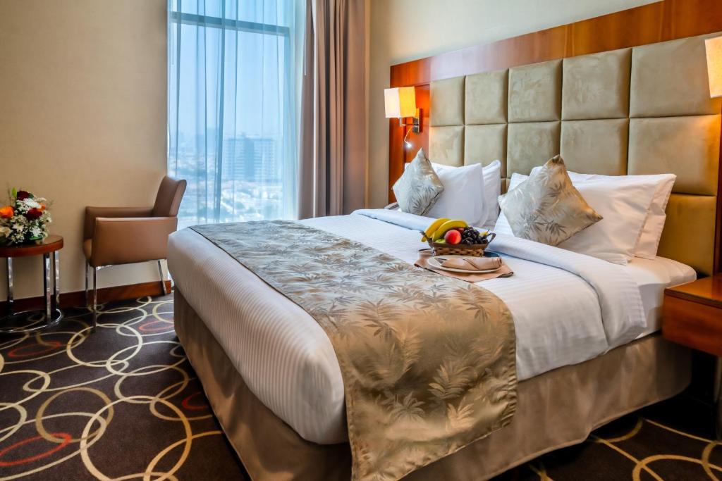 a hotel room with a large bed and a window at Montreal Barsha Hotel in Dubai