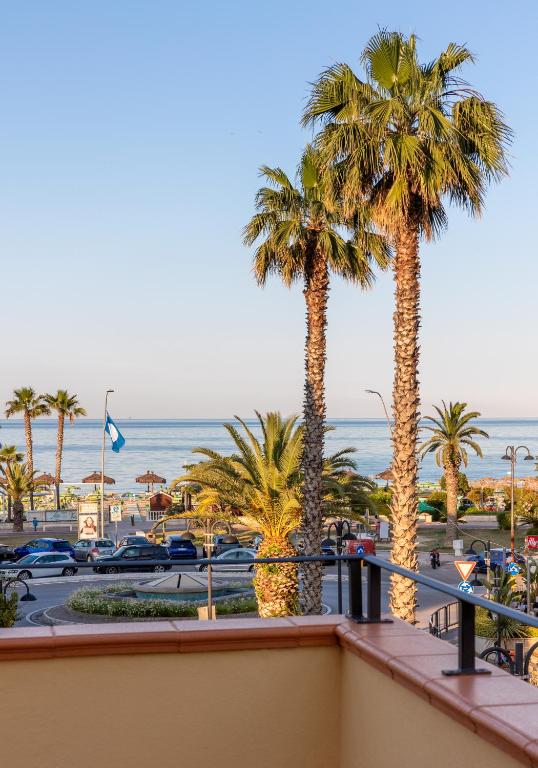 balkon z palmami i widokiem na ocean w obiekcie Discover Tortoreto w mieście Tortoreto Lido