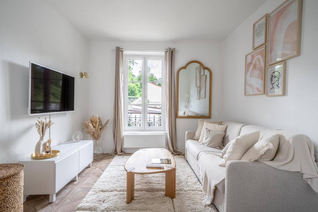 un salon blanc avec un canapé et une table dans l'établissement La Versaillaise Bucolique - Stationnement privatif - Proche Gare Chantiers, à Versailles