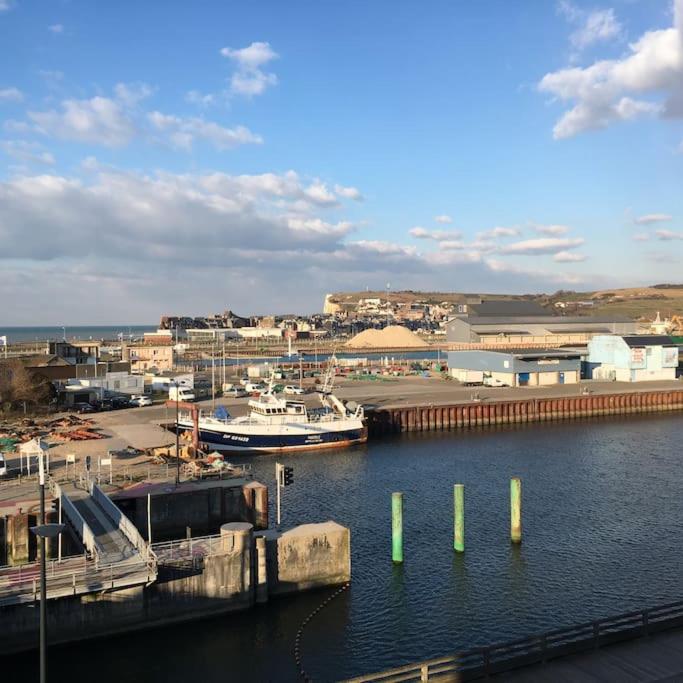 une marina avec deux bateaux dans l'eau et un quai dans l'établissement Appartement cosy vue mer, au Tréport