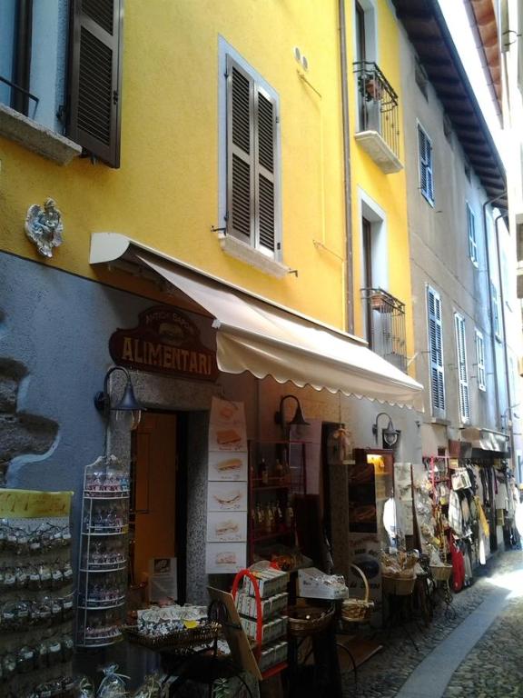 un bâtiment jaune avec un magasin dans une rue dans l'établissement Da Giusy, à Stresa