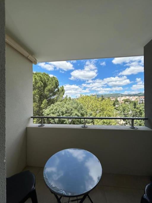 d'une table et d'une chaise sur un balcon avec une fenêtre. dans l'établissement Duplex Neuf et Cosy avec Place Parking, à Plan-de-Cuques
