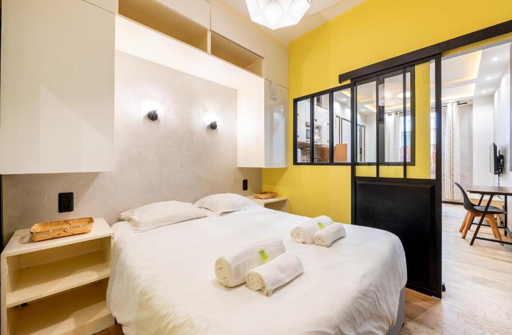 une chambre avec un grand lit blanc avec des serviettes dessus dans l'établissement Full-Equipped & Near to Subway, à Paris