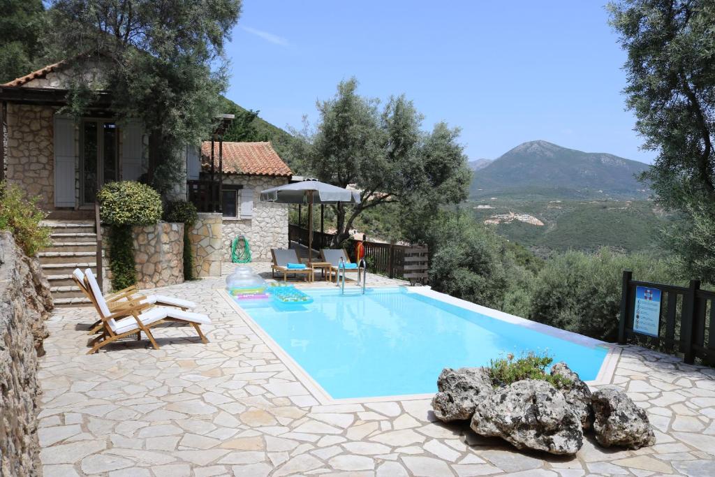 a swimming pool in front of a house at Arriva Villas in Sivota