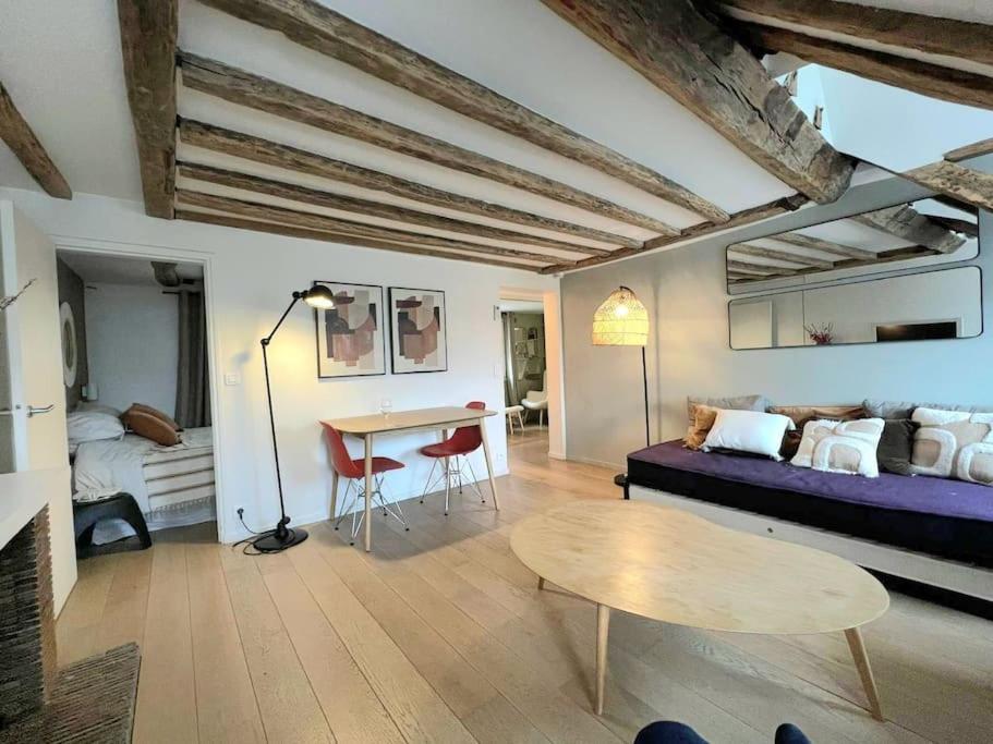 un salon avec un canapé et une table dans l'établissement Elegant Loft Place Vendôme, à Paris